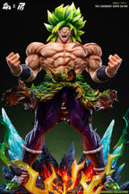 A highly detailed collectible statue of Broly from Dragon Ball Z in a Super Saiyan form, standing on a fiery, crystal-laden base against a dark background. The figure features spiky green hair, muscular skin, a green and orange leafy waist sash, and purple pants.