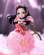 A small anime figurine of a character sitting on a pink flower-like fruit, with Chinese promotional text and One Piece branding visible. The product is centered against a soft pink and purple blurred background.